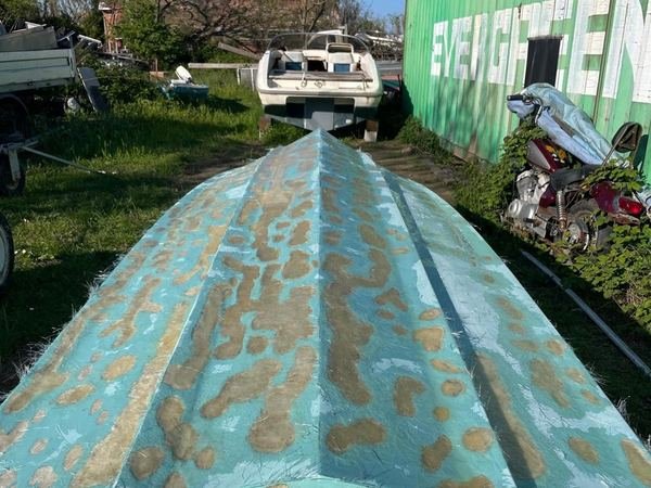 Coperta di una barca butterata da vesciche e chiazze stuccate, prima della ripresa