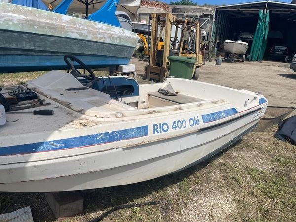 Open in vetroresina con vernice bianca e blu sbiadita e fiancata segnata, prima dell'intervento