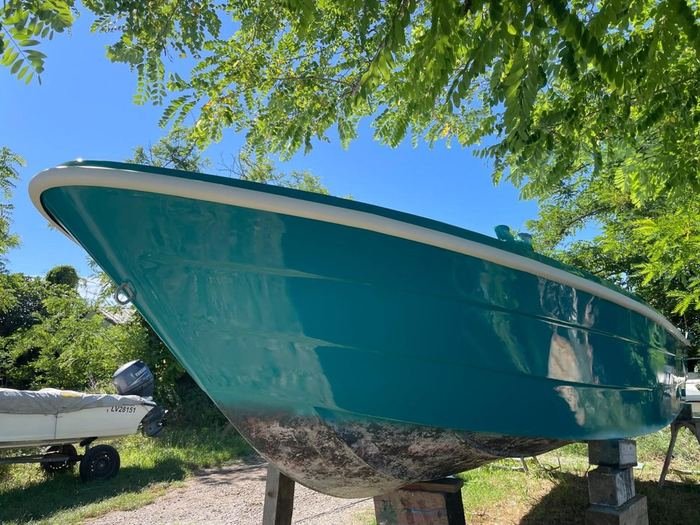 Prua di una barca riverniciata di turchese, sugli invasi